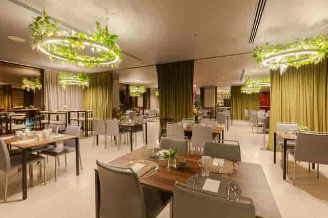 Maximiliano biophilic dining space with modular furniture for corporate events and workshops.