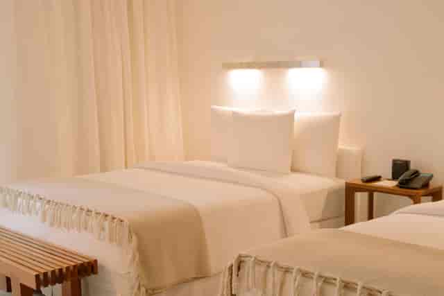 Double-occupancy hotel room with neutral decor for conference room blocks and business events.