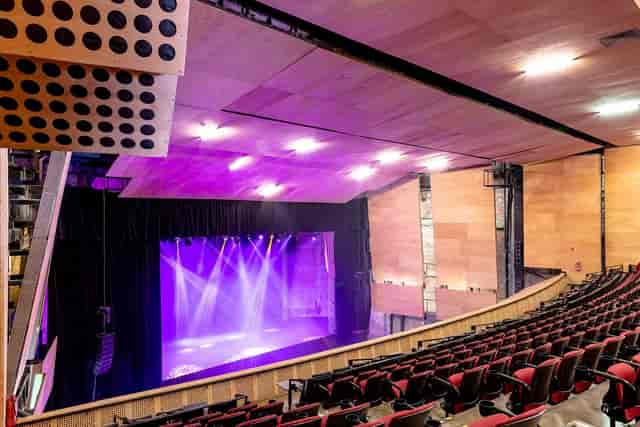 Modern proscenium theater in Foro Allende 5 with purple stage lighting for events and productions.