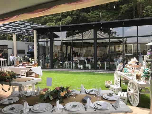 Modern glass banquet hall and garden courtyard for indoor-outdoor corporate events and weddings.