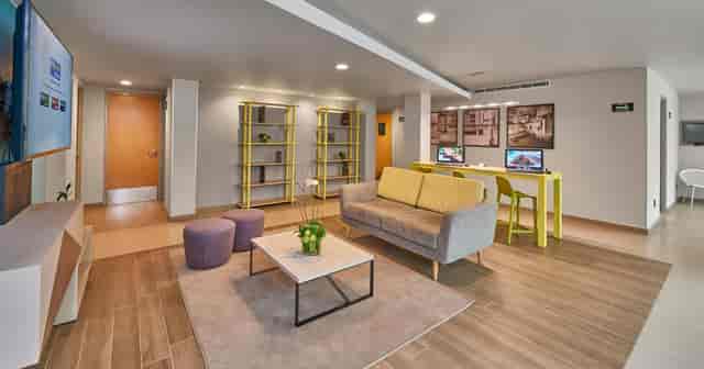 City Express Suites Mexico City event breakout space with lounge seating and workstations.