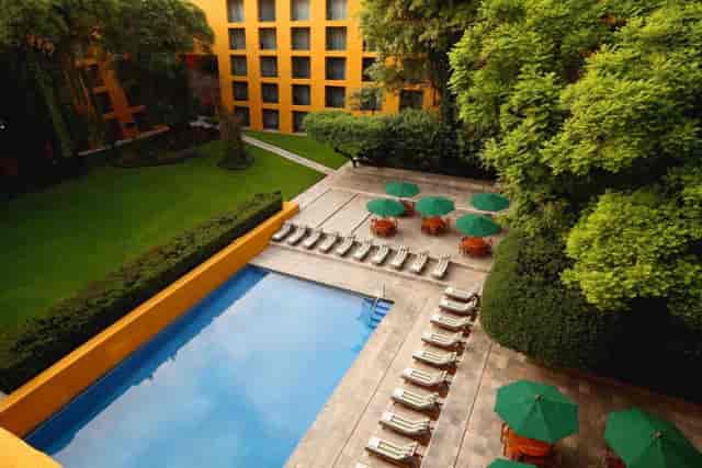 Outdoor swimming pool and lounge area at Camino Real Polanco for corporate events and networking.