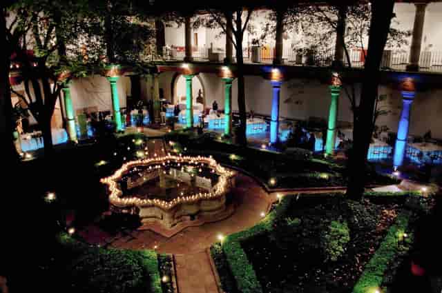 Gala at Museo Franz Mayer: atmospheric courtyard with pillar uplighting and candle centerpiece.