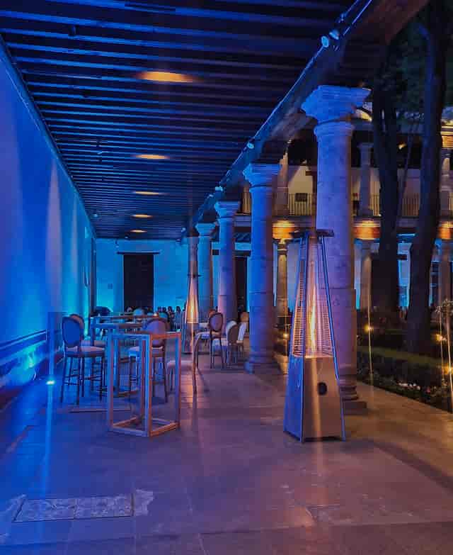 Blue-lit Sala del Claustro at Museo Franz Mayer, an atmospheric event venue for corporate receptions.