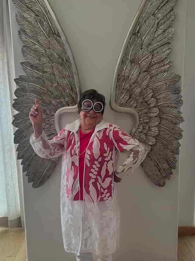Angel wing step-and-repeat at a milestone birthday celebration event photo booth.