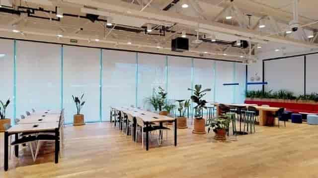 Modern WeWork meeting room with industrial ceilings for corporate workshops and hybrid gatherings.