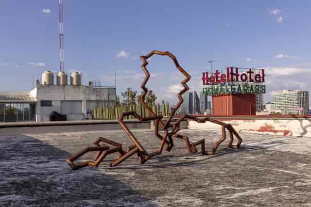 Industrial rooftop gallery venue with sculptural art for edgy experiential corporate events.