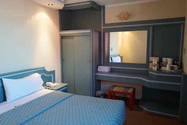 Standard suite at Hotel Mónaco CDMX, dated room decor for business travel accommodation.
