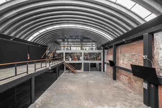 Industrial-chic Salón Principal at Lucerna 32 featuring vaulted ceilings for experiential events.