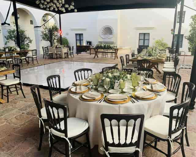 Elegant courtyard event venue with white tables and dance floor for weddings and gala receptions.