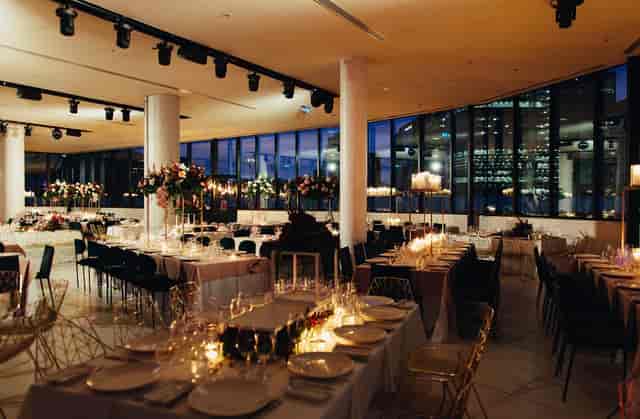 Upscale gala banquet hall with city views and elegant table settings for corporate events.