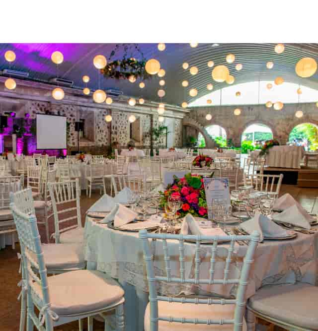 Rustic event hall with paper lanterns for corporate dinners and elegant weddings.