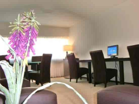 Las Suites business center with dated decor, ideal for corporate meetings and remote work.