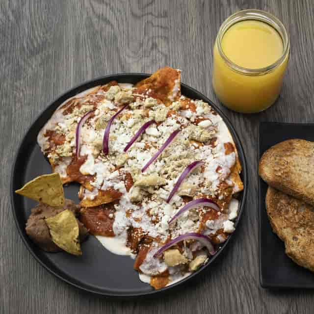 Catering breakfast with chilaquiles and juice for a corporate business brunch meeting.