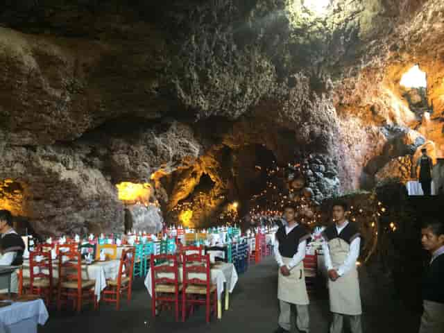 La Gruta Restaurant: Cave venue with colorful seating for bespoke corporate banquet events.