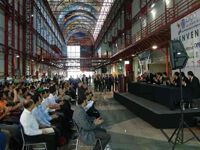 VIP Area industrial venue with stage for keynote session and theater-style corporate event seating.