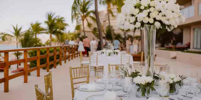 Luxury Infinity Club Deck wedding reception with gold chairs and floral decor at Grand Fiesta.
