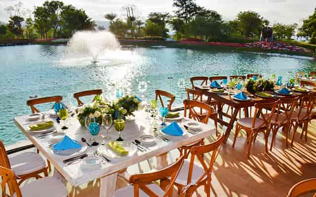 Waterfront banquet hall with wood chairs for outdoor wedding reception and corporate event venue.