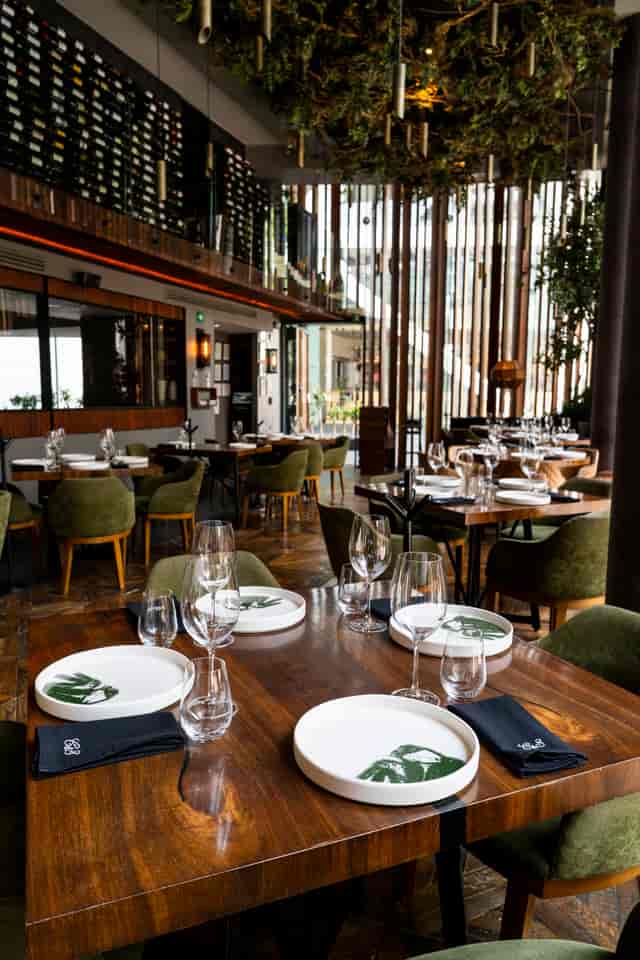 Coctelería at Carmela & Sal: Sophisticated olive seating for corporate dinners and networking.