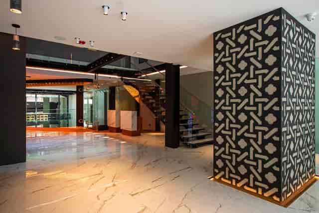 Contemporary pre-function foyer with geometric wall for luxury networking and guest registration.