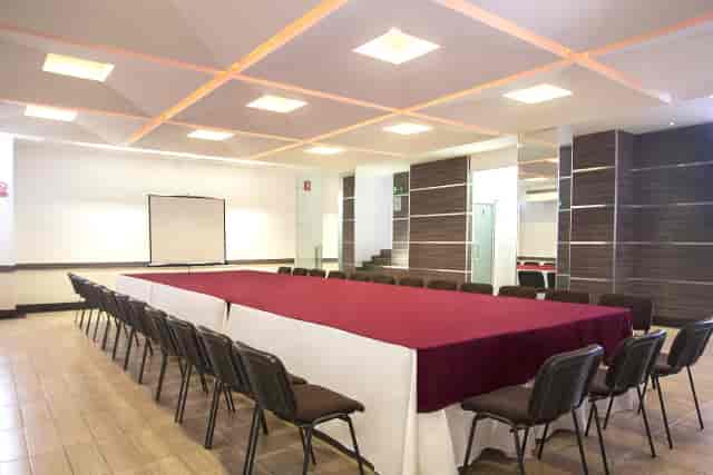 Salón Orizaba boardroom setup with red table for corporate meetings and business events.