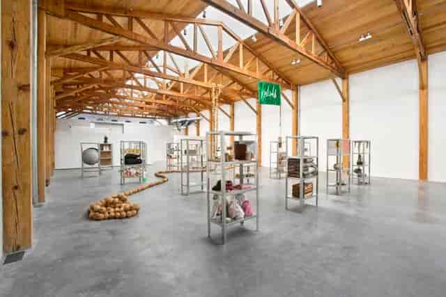 Industrial Kurimanzutto exhibition space with timber trusses for creative pop-up events.