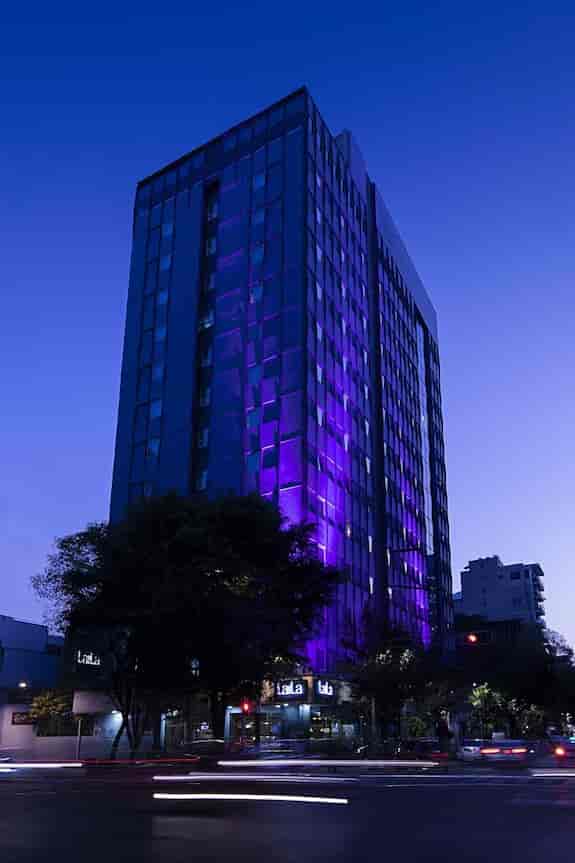 Modern Laila Hotel CDMX facade with accent lighting for corporate events and evening receptions.
