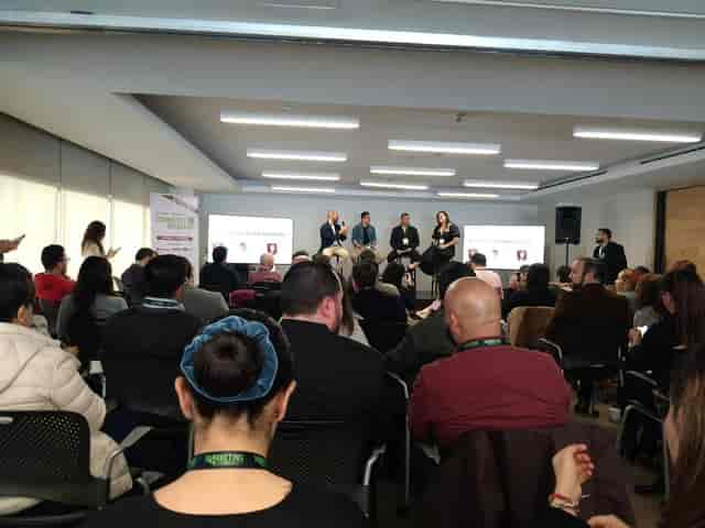 Panel discussion with four speakers in The Room business center for corporate events and conferences.