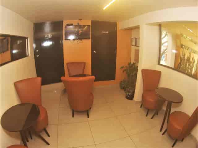 Cramped Hotel Jard Inn breakout room, television between restrooms for professional event meetings.
