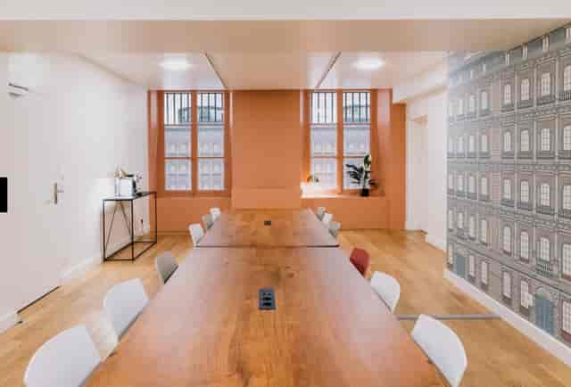 Modern meeting room with wooden table and natural light for collaborative events.