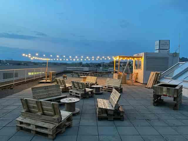 Rooftop restaurant with string lights, industrial-chic event space for casual parties.