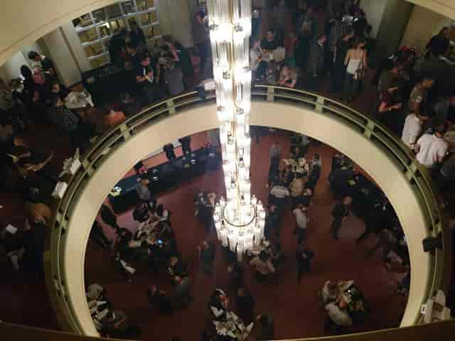 Networking reception in Salle Métropole featuring a central chandelier. Event venue, networking space.