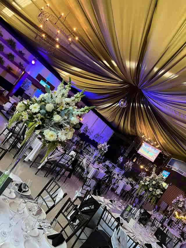 Gala event setup at Eventos Casablanca with ceiling draping and floral centerpieces.