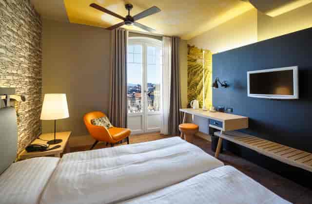 Modern hotel guest room with dedicated workspace for business meetings and corporate events.