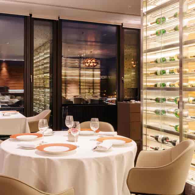 Intimate lounge with wine cellar backdrop for executive dinners and corporate events.