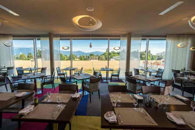 Bright banquet hall at Starling Hotel Lausanne with floor-to-ceiling windows for corporate events.