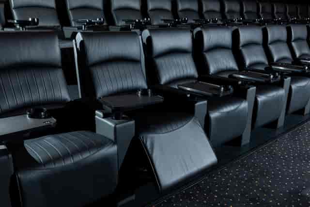 Plush black theater seats with cup holders at Vue Leeds for corporate events.
