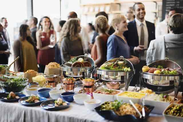 Caterer serving a buffet at a corporate networking reception event.