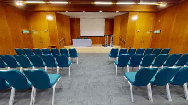 Small Hall at Kensington Centre: modern event space with blue chairs for conferences.
