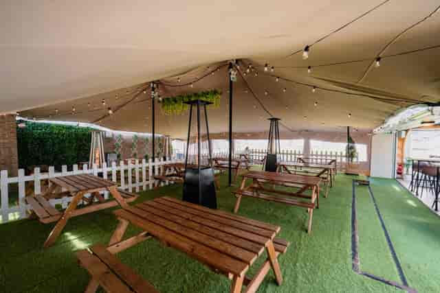 Outdoor event space at Finsbury Square with picnic tables and decorative lighting.