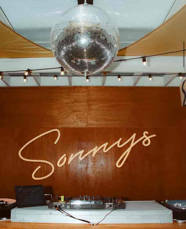 Sonnys Riviera Rooftop Bar with neon sign and disco ball for festive corporate or private events.