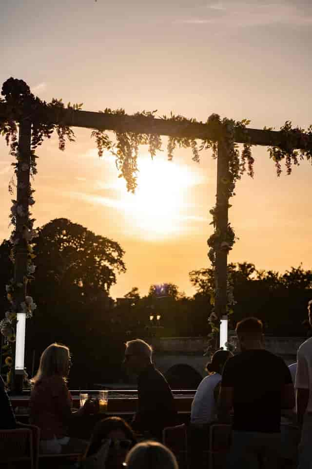 Floral-framed golden hour wedding ceremony on Riviera Rooftop Bar terrace for outdoor events.
