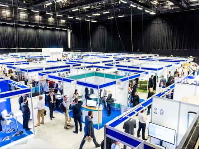 Brighton Centre exhibition hall bustling with vendors and attendees at a networking event.