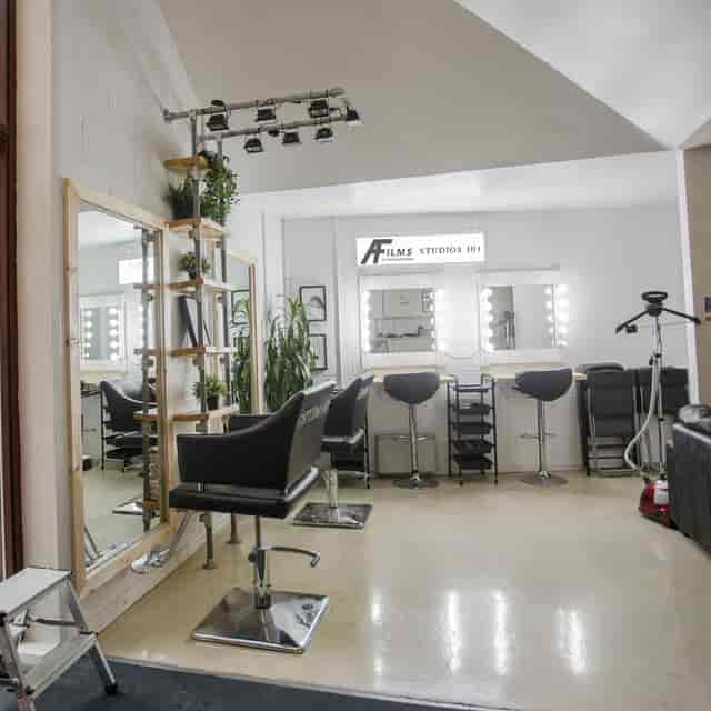 All-white makeup studio with mirrors and lighting for pre-event preparation.