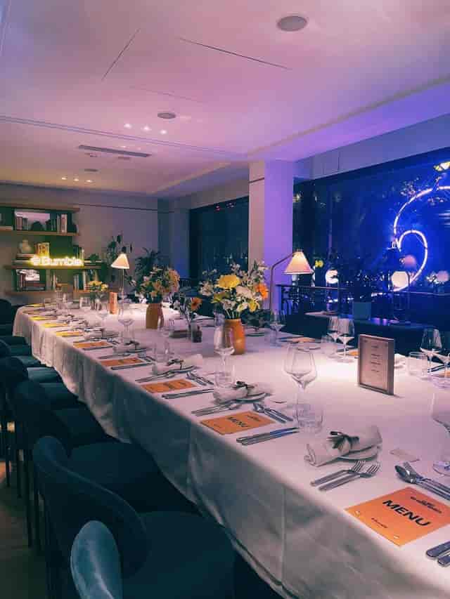 Elegant corporate event dining setup at Kimpton St Honoré Paris with floral arrangements.
