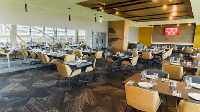 Modern lounge banquet hall with modular tables for corporate events and upscale dining.