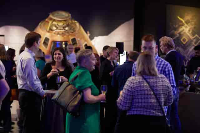 Networking event at The Science Museum with space-themed exhibit backdrop.