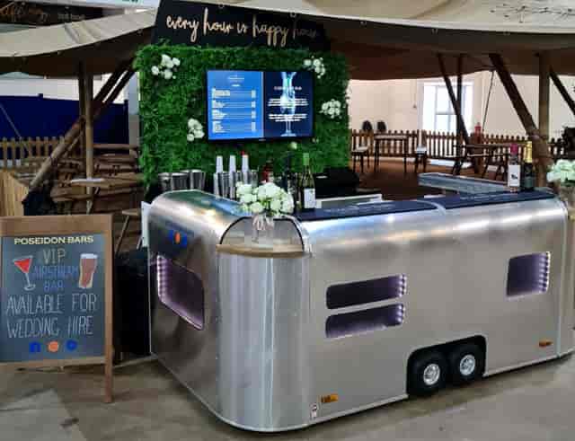 Modern mobile bar setup with floral decor for events and weddings.
