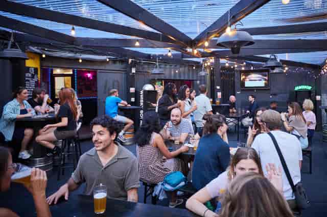 Casual networking at 40FT Brewery in a shipping container venue with high-top tables.