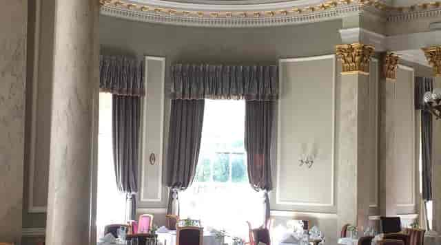 Elegant ballroom with gold molding and marble pillars for luxury galas and executive dining.
